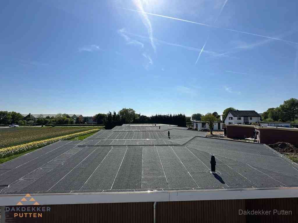 Groot plat dak met bitumen dakbedekking op bedrijfspand in Putten Groot plat dak met bitumen dakbedekking op bedrijfspand in Putten